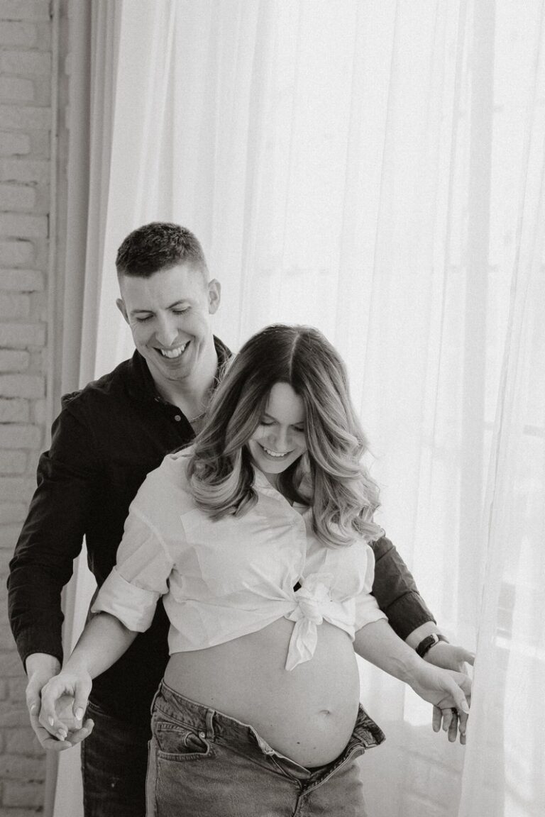 Nastávající rodiče se smějí během těhotenského focení v ateliéru v Praze