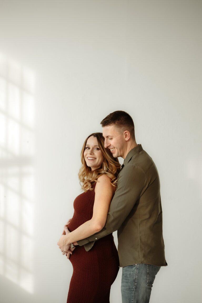 Nastávající rodiče se smějí při těhotenském focení v ateliéru Praha