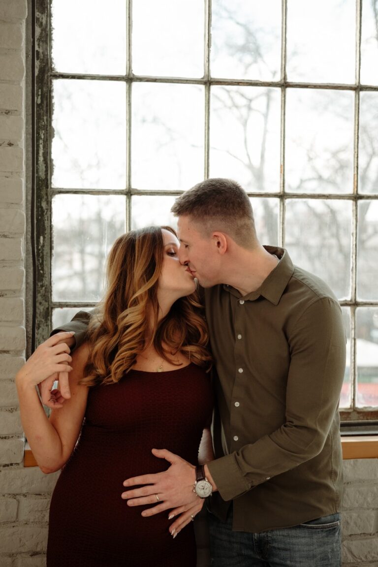 Nastávající rodiče se objímají při těhotenském focení v ateliéru Praha