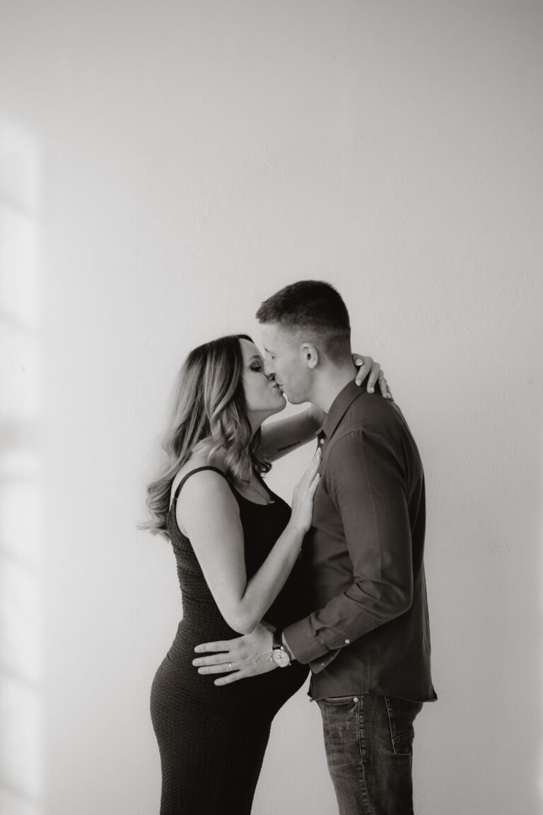 Nastávající rodiče si dávají pusu při těhotenském focení v ateliéru Praha