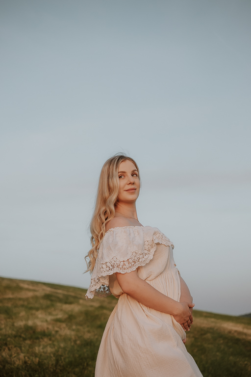 Těhotenské focení Praha – fotografie ženy čekající miminko v bílých romantických šatech
