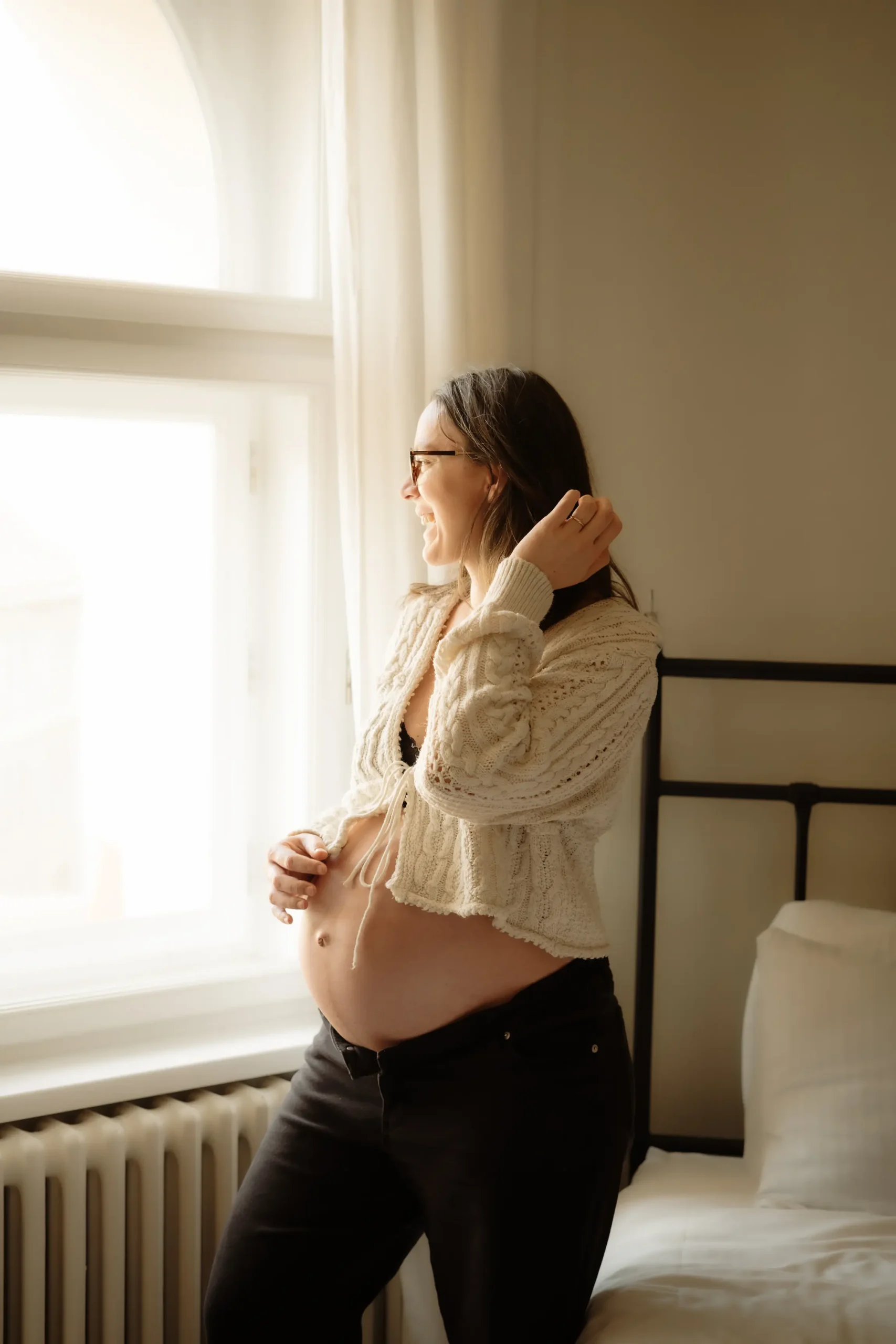 přirozený portrét těhotné ženy při domácím těhotenském focení u okna